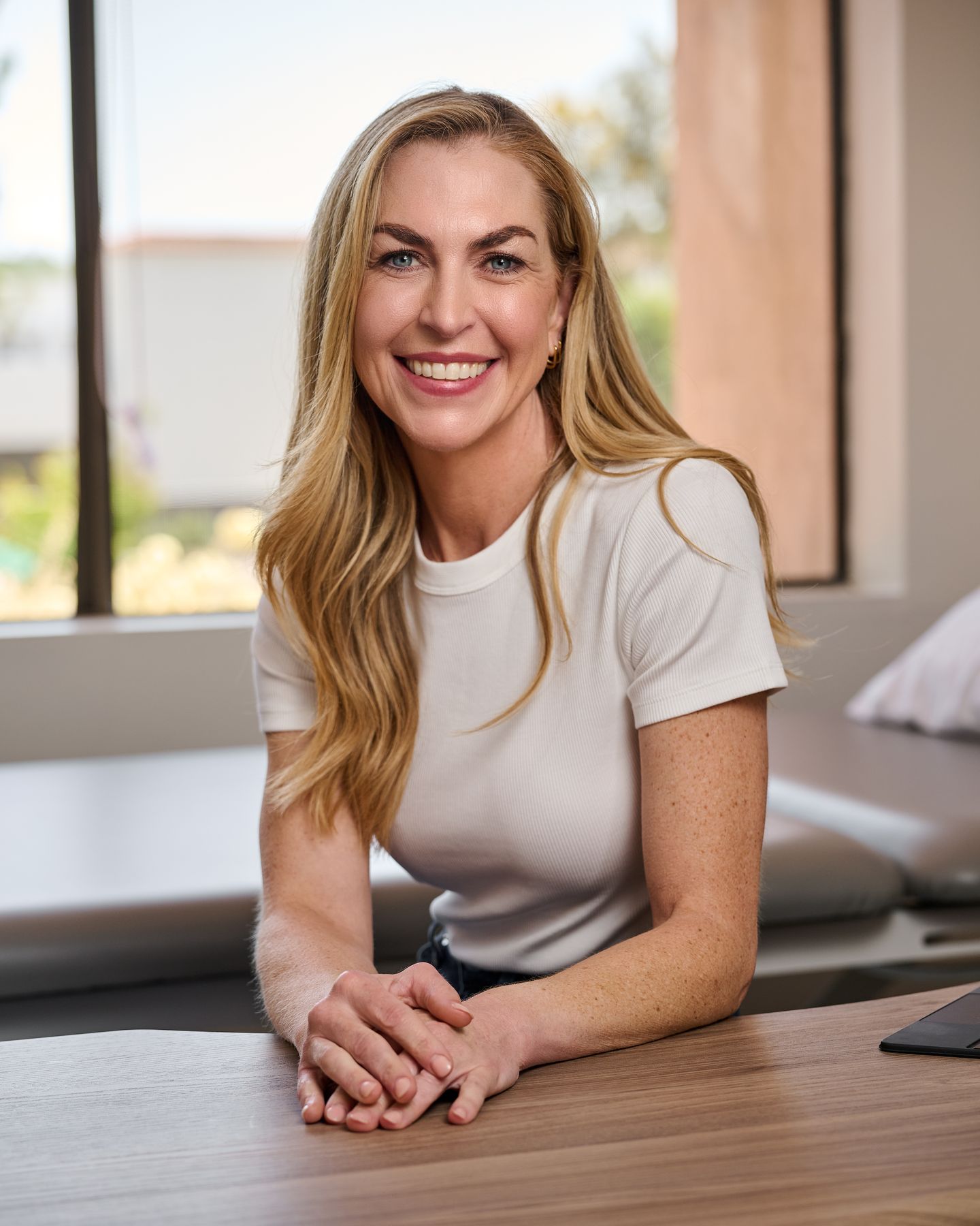 Portrait of Kate Silverman, Certified Hand Therapist, smiling at her desk in her Santa Barbara clinic
