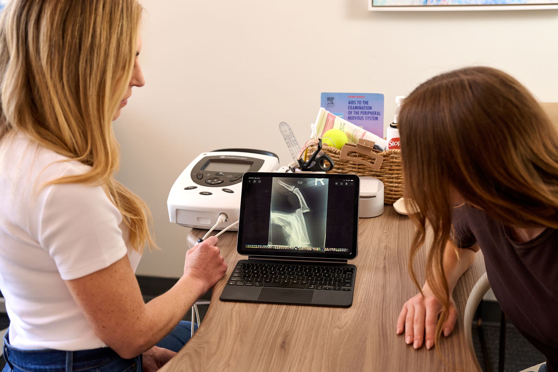 Kate reviewing a hand X-ray on a tablet with a patient
